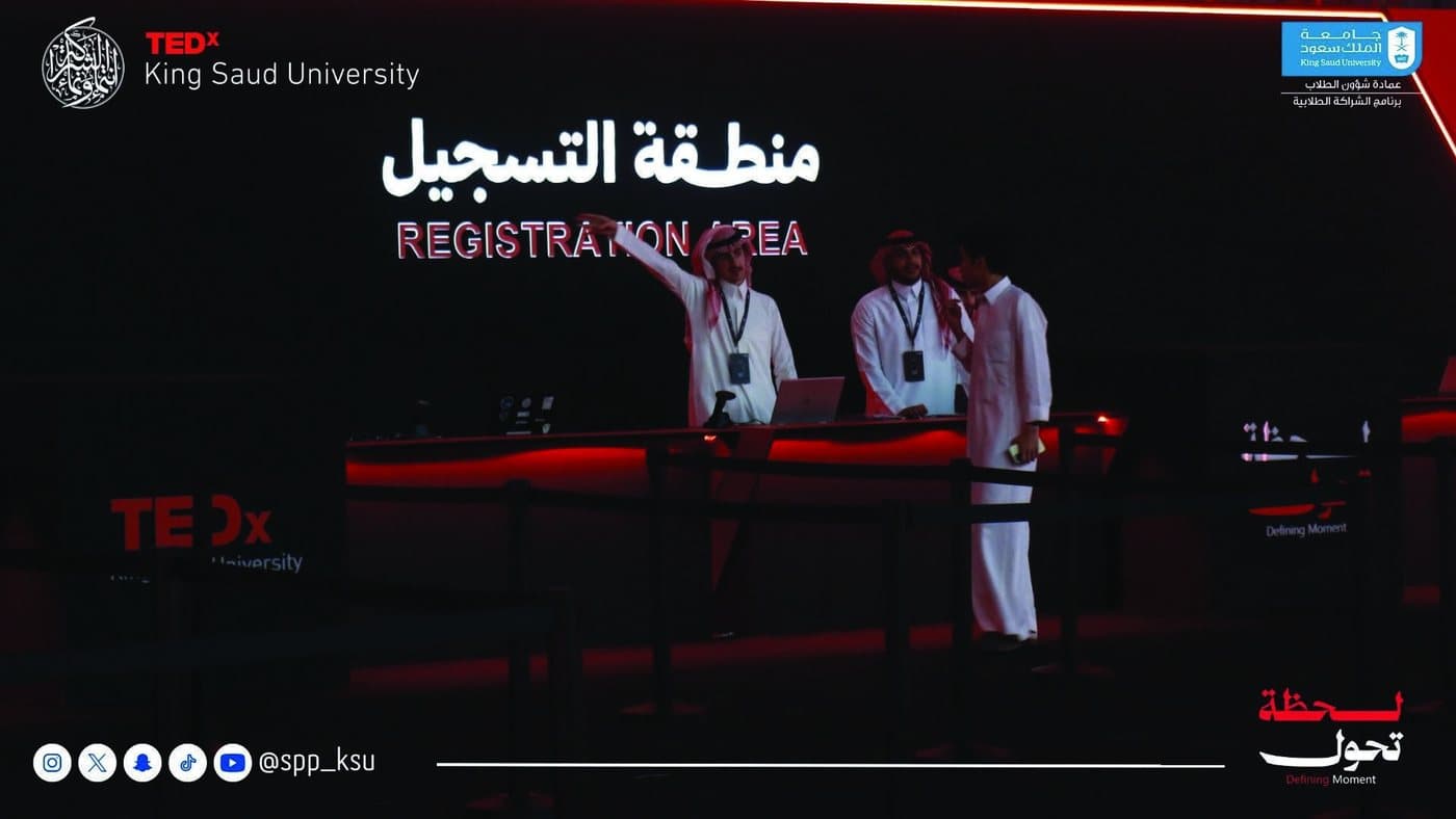 A staffed registration desk at a METAC-managed event, with laptops, screens and directional signage