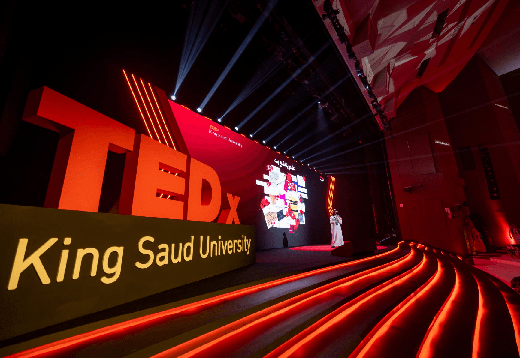 TEDx King Saud University event stage lit in red